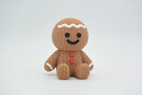 Close-up of a knitted gingerbread man decoration with white icing detail and soft woven texture, 49 DKK