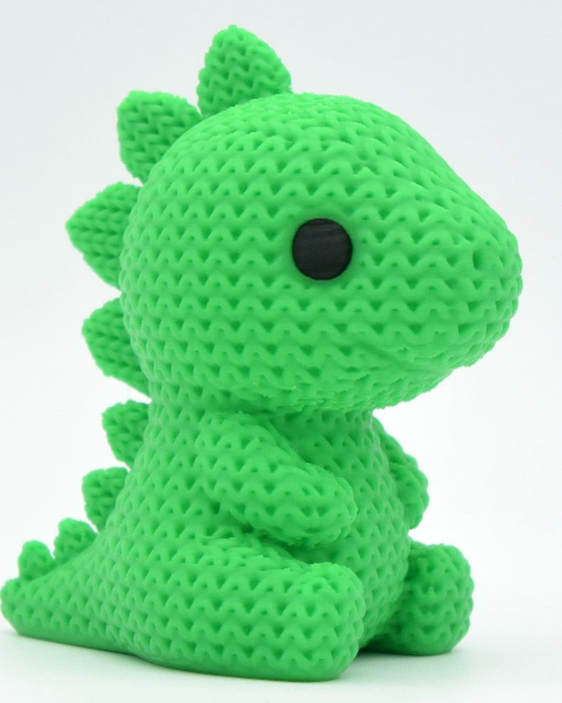 Close-up of a knitted stegosaurus figurine in green with crochet-texture surface and small painted eyes