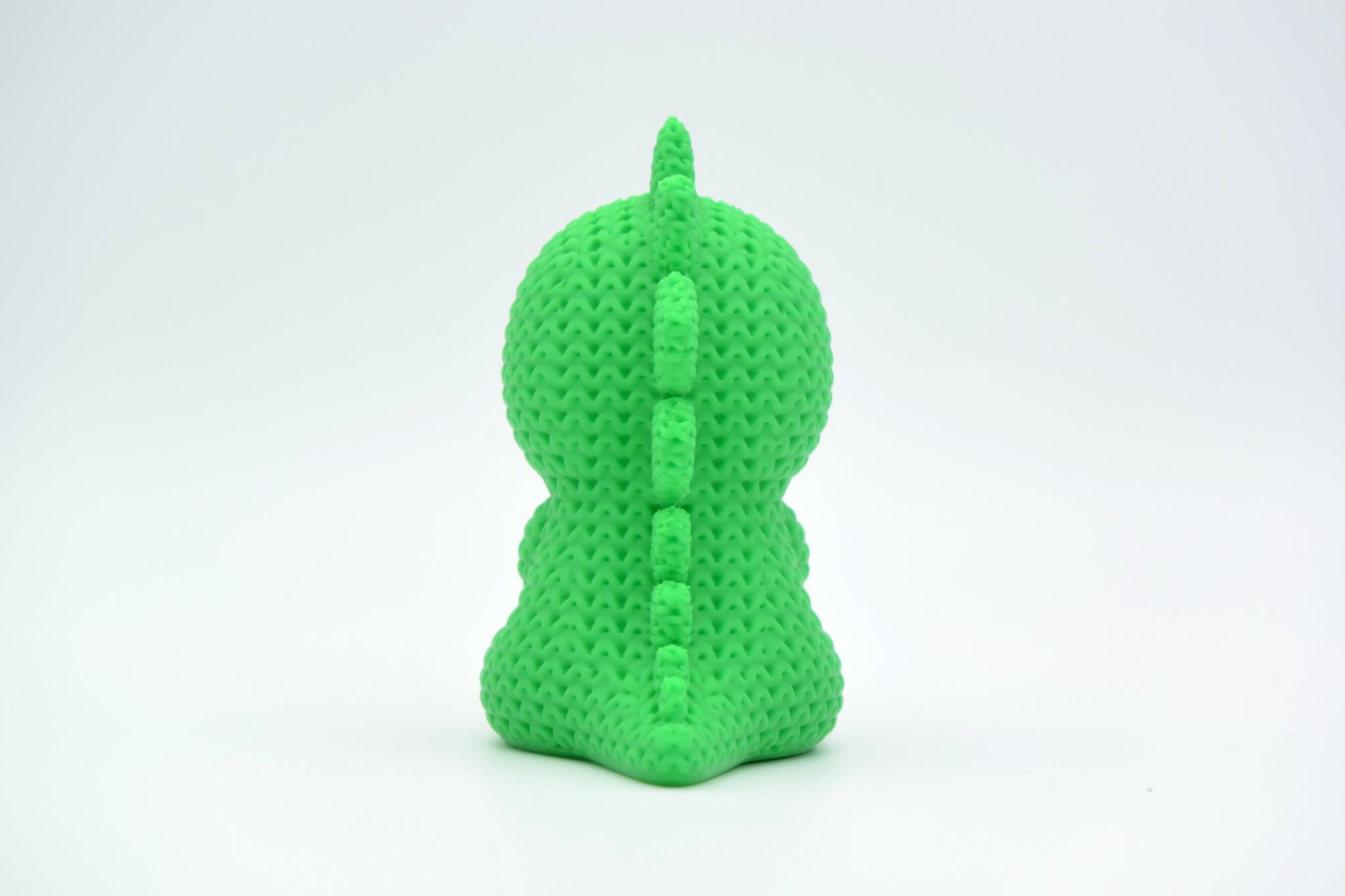 Texture detail of the crochet-look surface and dorsal plates on a green stegosaurus figurine