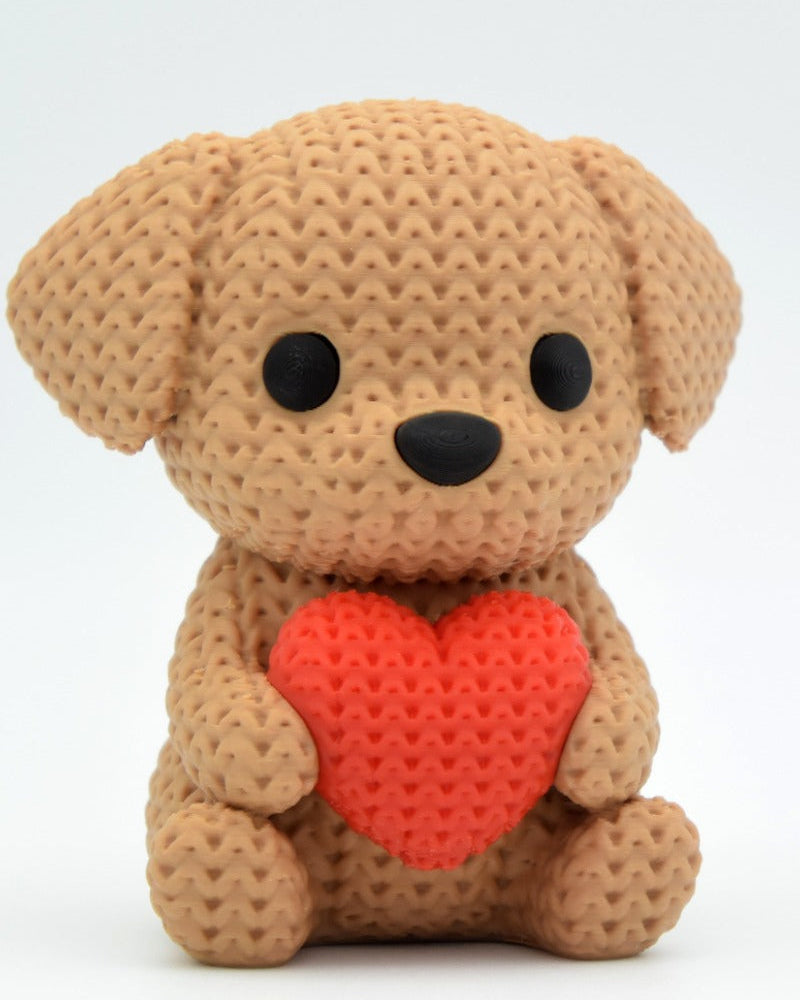 Close-up of a crochet dog ornament holding a small heart, showing soft looping texture across the body