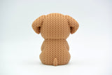 Close-up of a crochet dog ornament holding a small heart, showing soft looping texture across the body