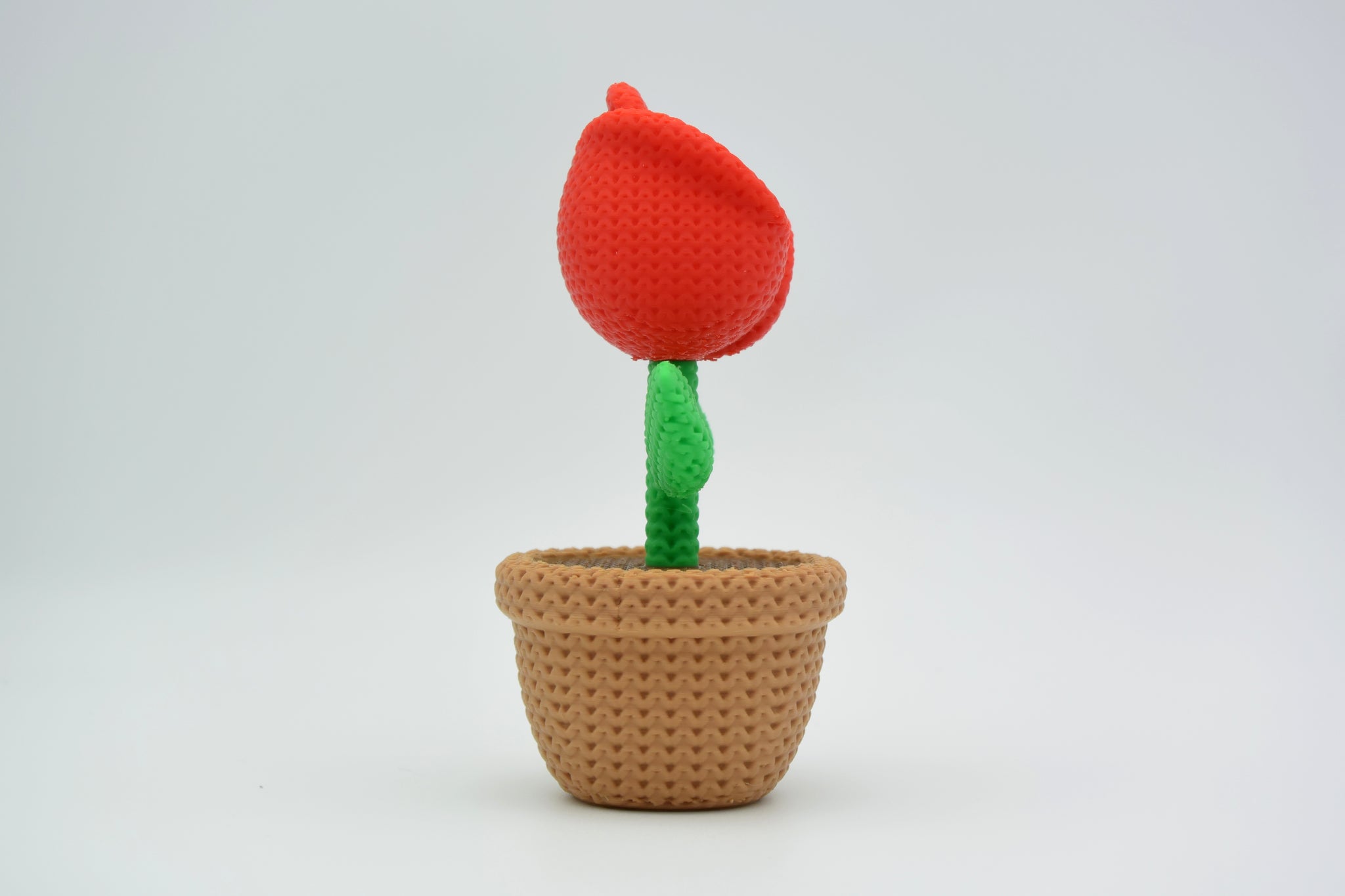 Detail shot of the knitted rose surface showing the layered textile-like texture of each petal