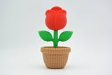 Close-up of a decorative knitted rose with soft petal texture and warm red tones