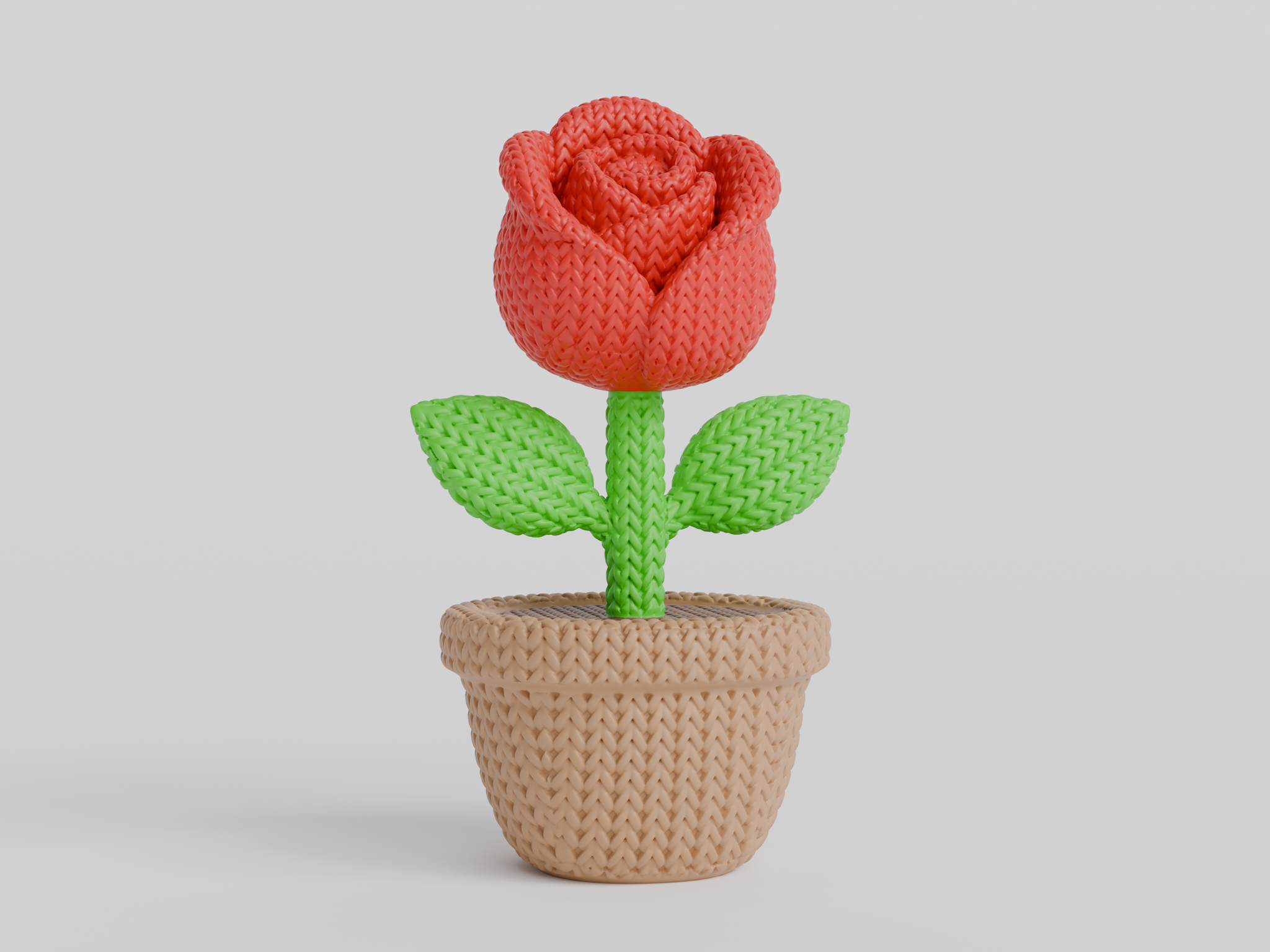 Close-up of a decorative knitted rose with soft petal texture and warm red tones