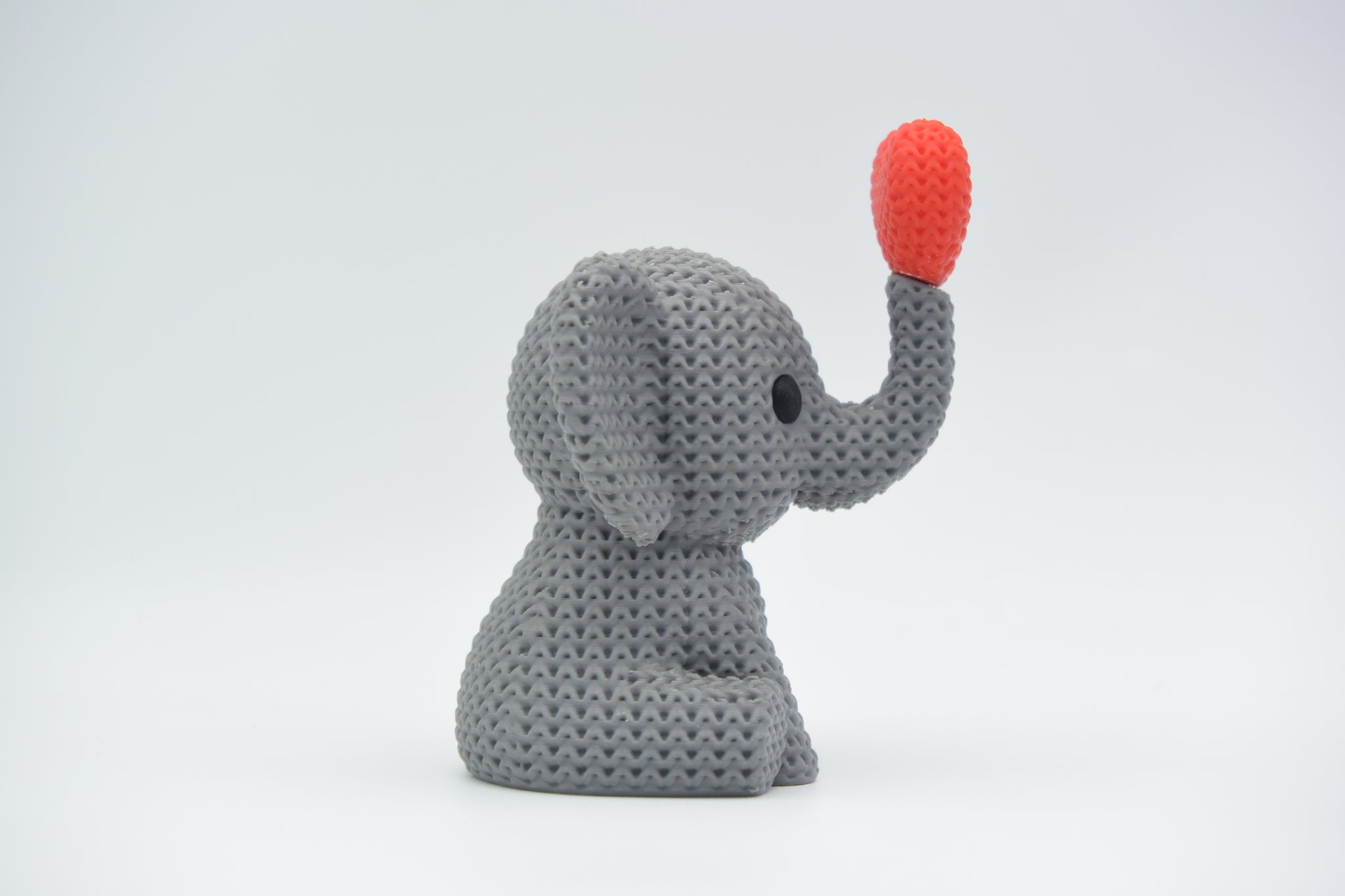 Texture detail of knitted elephant decoration showing open loop pattern across the elephant's body and heart