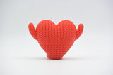Detail shot of the woven knit texture on a red heart-shaped decorative figure, showing the soft surface pattern
