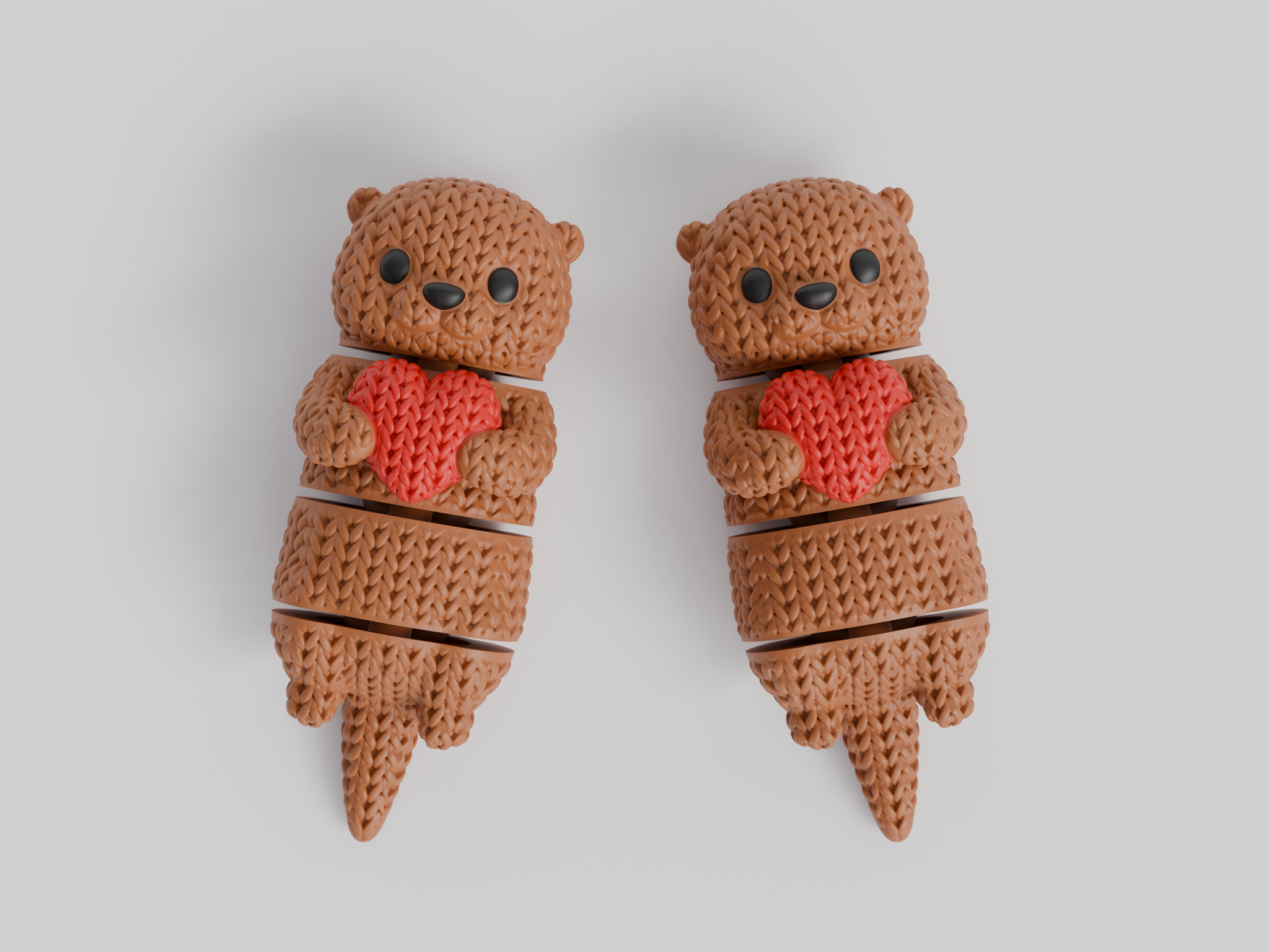 Close-up of a knitted articulated otter holding a small heart, showing soft crochet-texture surface detail