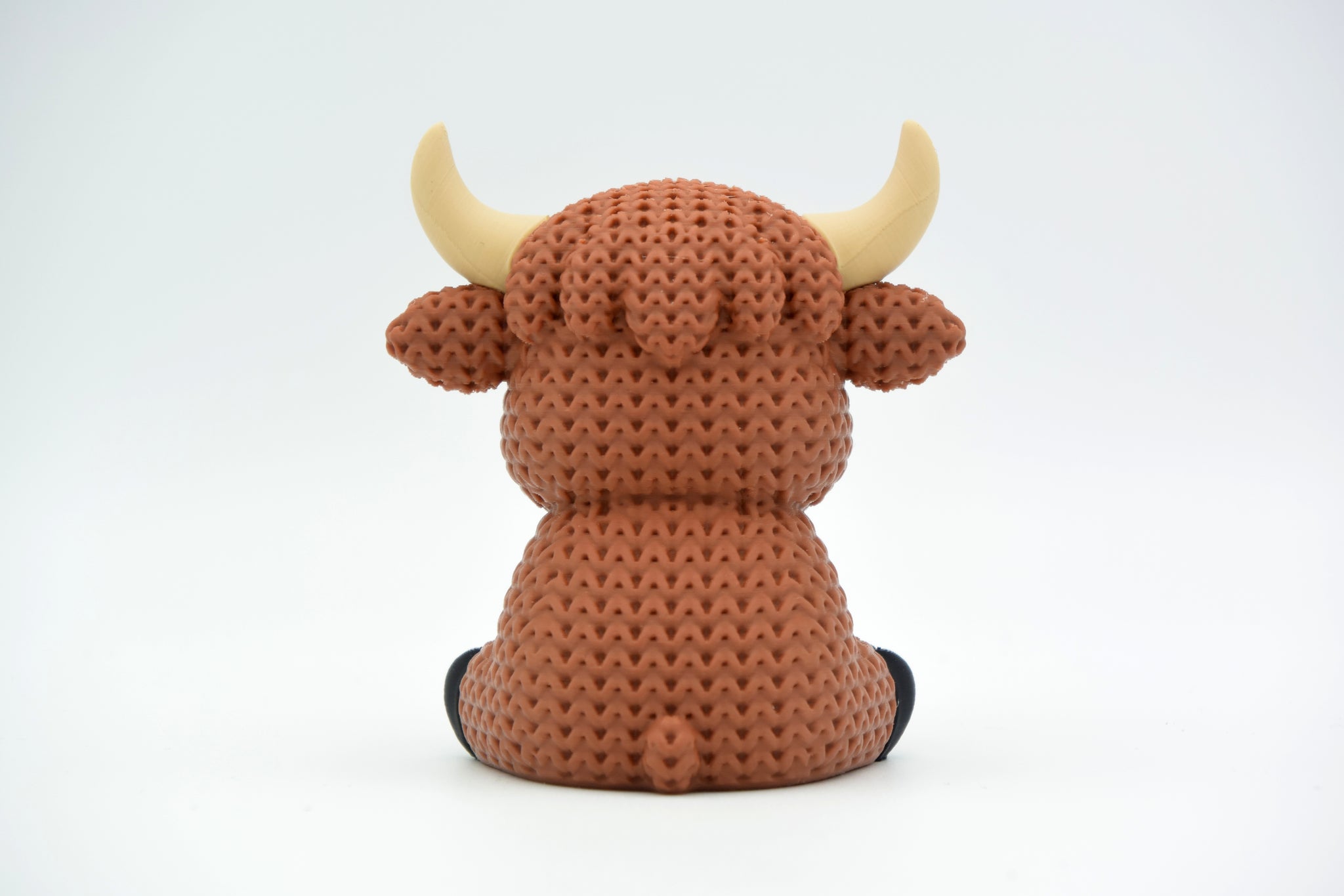 Detail shot of the crochet-look texture on a highland cow figure, showing the layered, yarn-like surface pattern