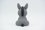 Texture detail of the knitted donkey showing the raised crochet-style surface pattern in warm light