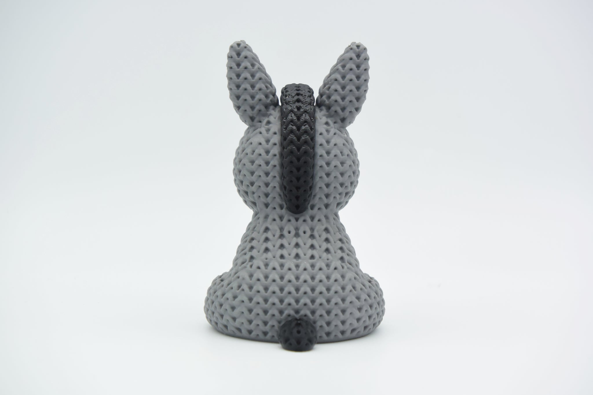 Texture detail of the knitted donkey showing the raised crochet-style surface pattern in warm light