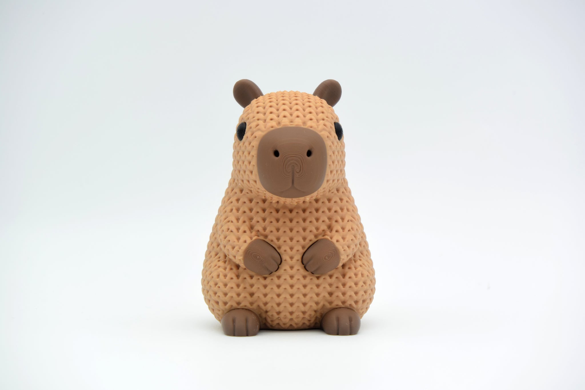 Texture detail of knitted capybara showing the open crochet-like weave pattern across the body of the figure