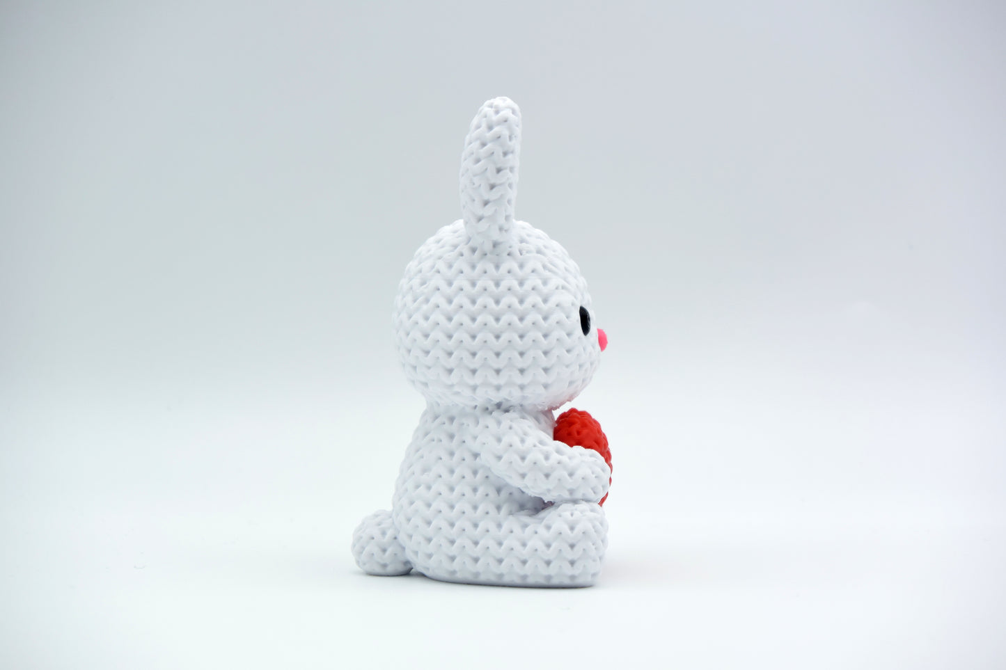 Knitted bunny with heart styled on a wooden shelf with spring flowers and neutral Easter decor