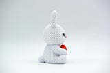 Knitted bunny with heart styled on a wooden shelf with spring flowers and neutral Easter decor