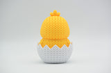 Texture detail of the knitted surface on a hatching chick Easter figure, showing the woven stitch pattern