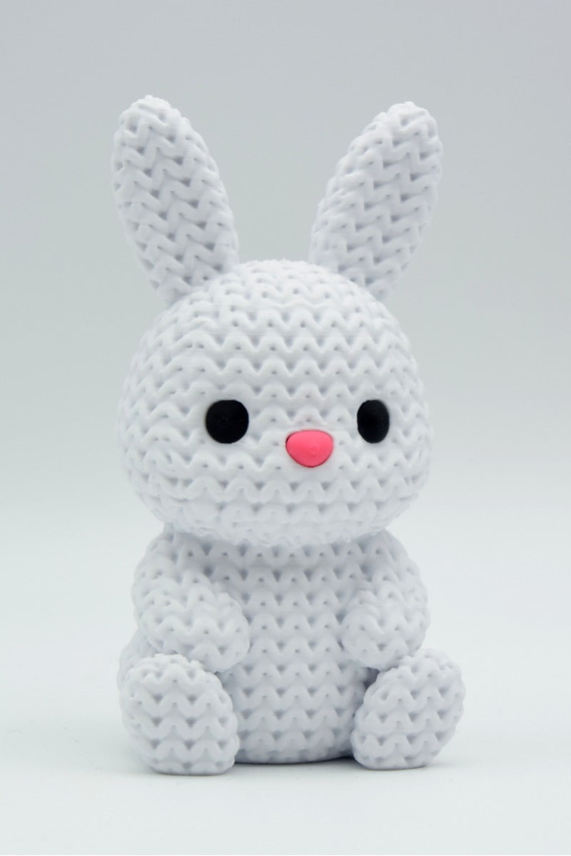Close-up of a small knitted bunny decoration with soft crochet texture, white background, 49 DKK
