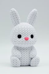 Close-up of a small knitted bunny decoration with soft crochet texture, white background, 49 DKK