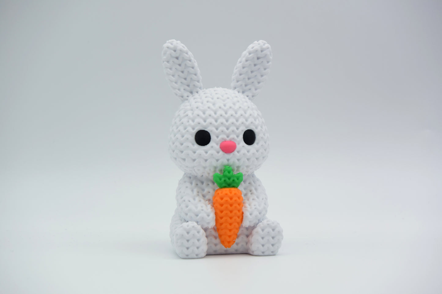 Knitted bunny with carrot styled on a wooden shelf with Easter greenery and neutral home decor