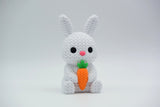 Knitted bunny with carrot styled on a wooden shelf with Easter greenery and neutral home decor