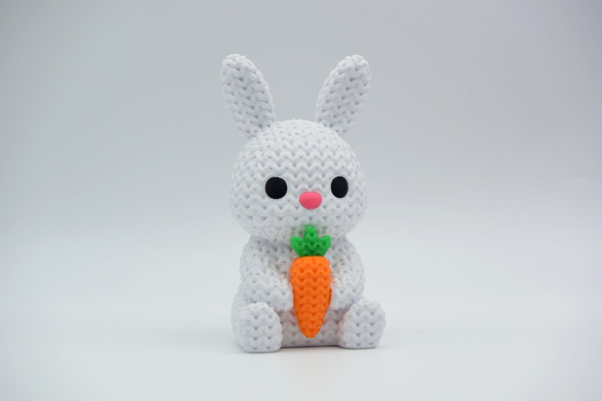 Knitted bunny with carrot styled on a wooden shelf with Easter greenery and neutral home decor