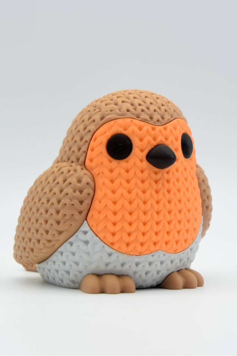 Close-up of a knitted robin bird figure with textured crochet-look surface and warm red breast, 49 DKK