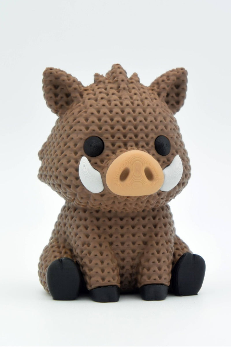 Close-up of a knitted wild boar figurine with a soft crochet-look texture, shown against a light background