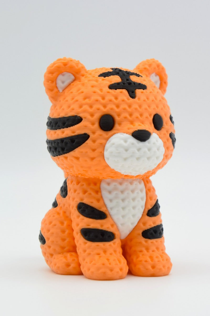 Close-up of a knitted tiger figurine with textured yarn-like surface and bold orange and black stripes