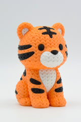 Close-up of a knitted tiger figurine with textured yarn-like surface and bold orange and black stripes