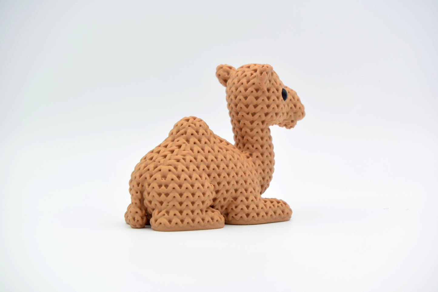 Detail of the knitted texture on a camel figurine, showing the cross-hatched surface pattern