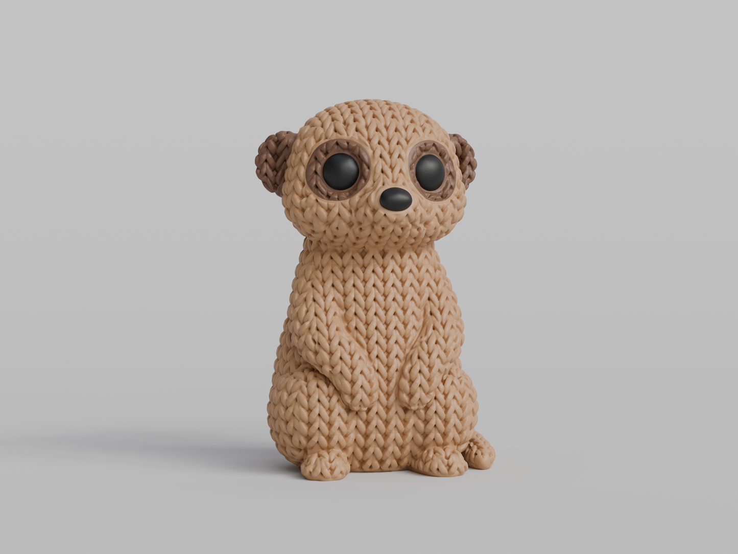 Close-up of a knitted meerkat figurine with a crochet-texture surface, standing upright on a white background