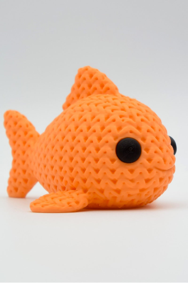 Close-up of a knitted fish decoration showing soft woven texture and small round eyes, 49 DKK