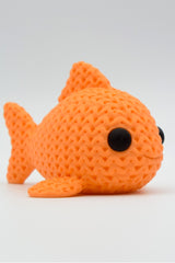 Close-up of a knitted fish decoration showing soft woven texture and small round eyes, 49 DKK