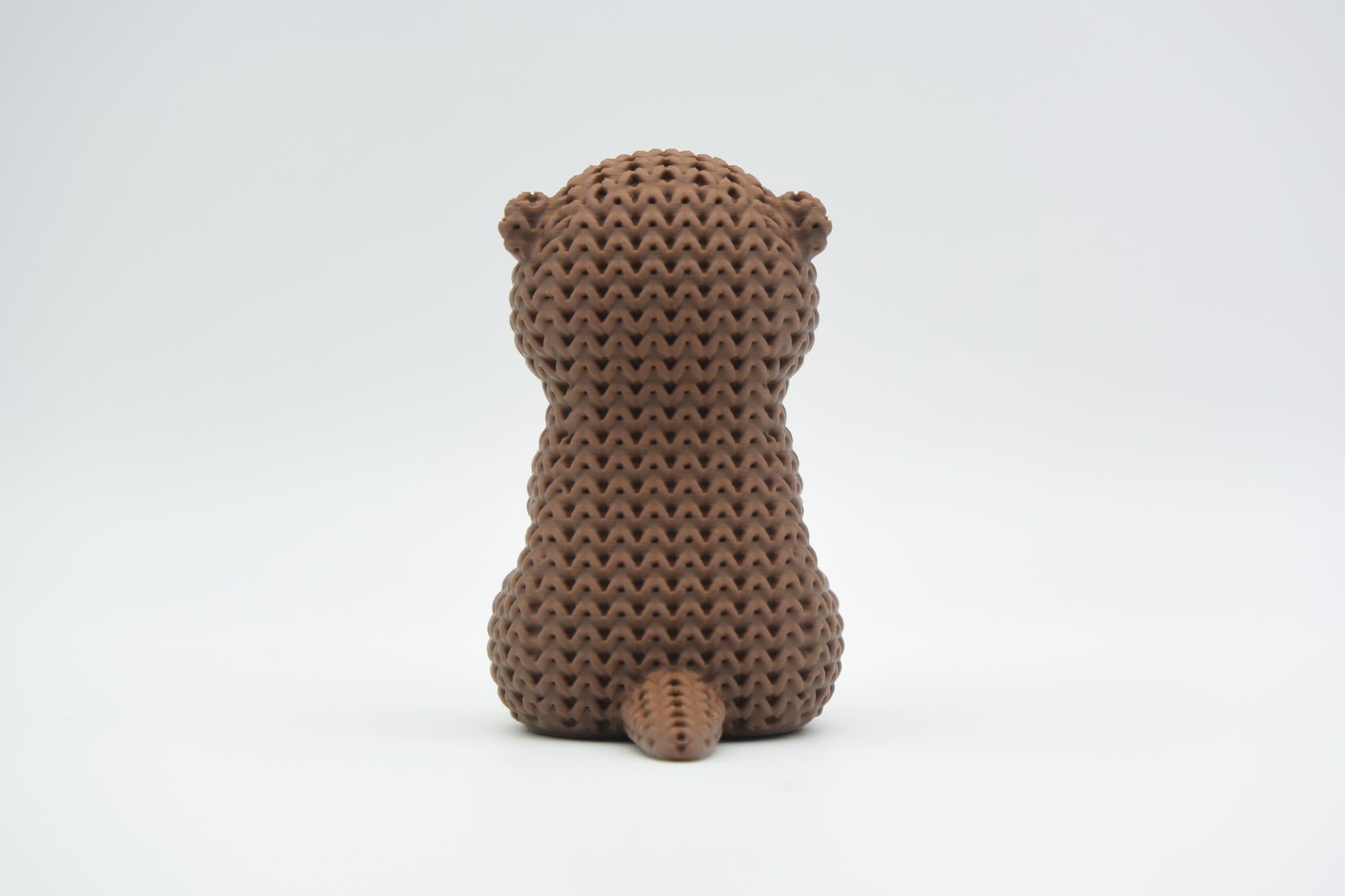 Texture detail of the knitted otter showing the woven loop pattern that gives the surface its handcrafted crochet look
