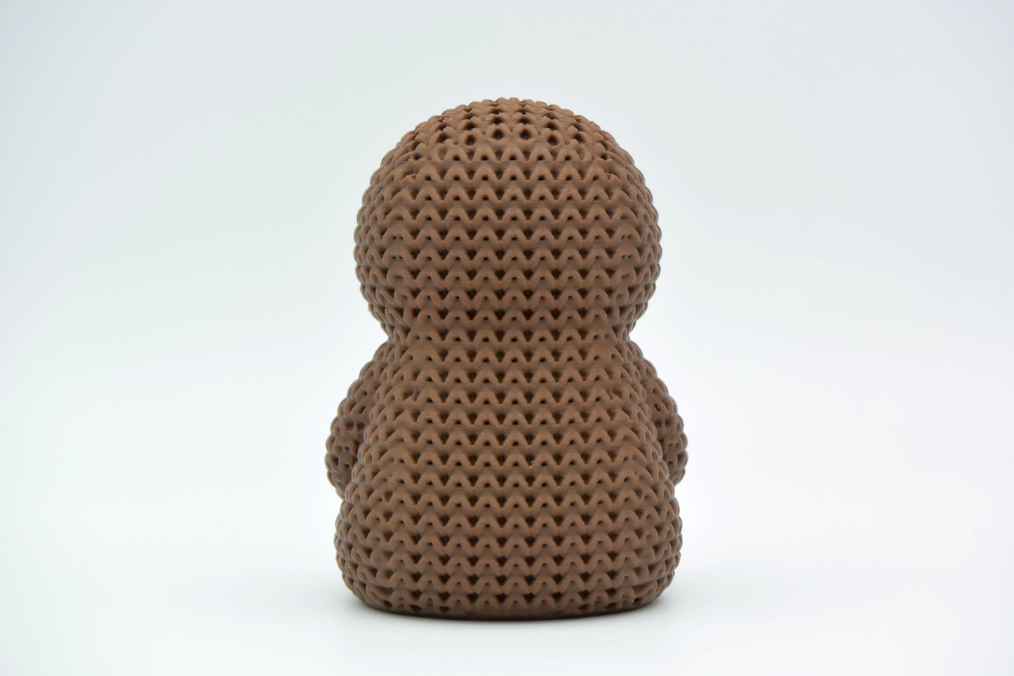 Detail shot of the crochet-look surface texture on a knitted sloth figure, showing stitched pattern relief