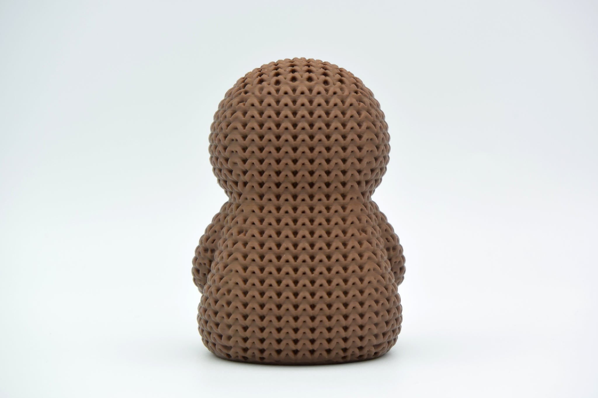 Detail shot of the crochet-look surface texture on a knitted sloth figure, showing stitched pattern relief