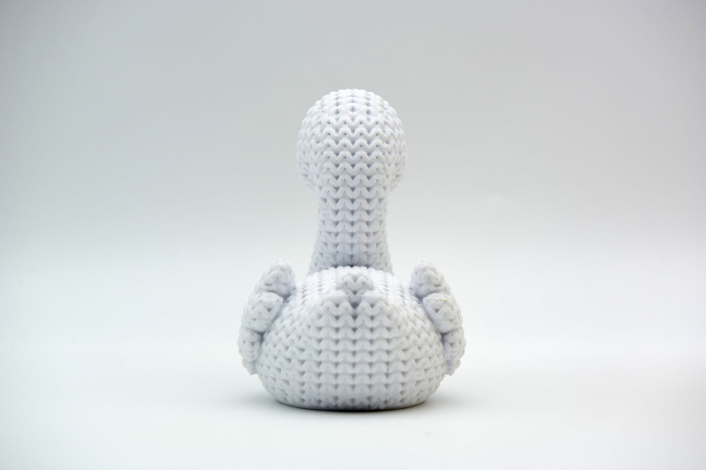 Detail shot of the woven surface texture on a knitted swan figurine, showing the stitch-like pattern