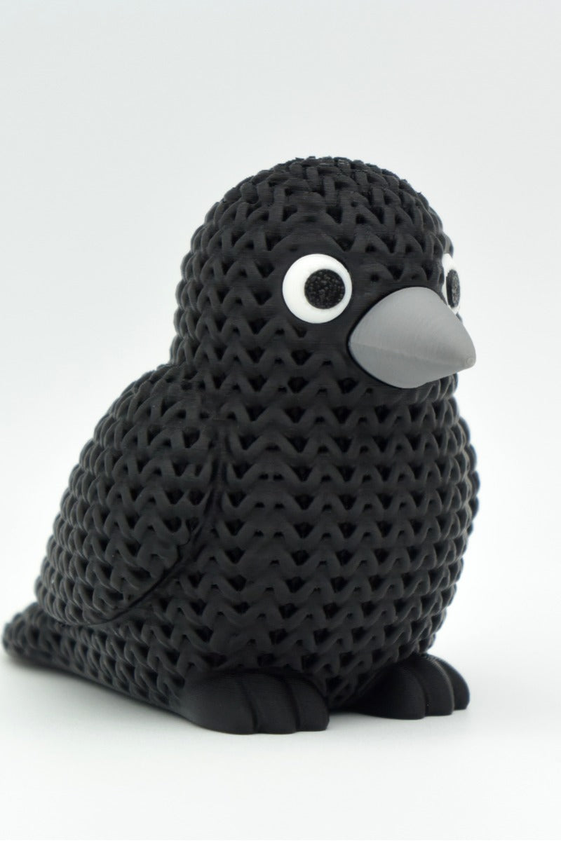 Close-up of a knitted crow figurine with a crochet-look texture and detailed snap-fit eyes, 49 DKK