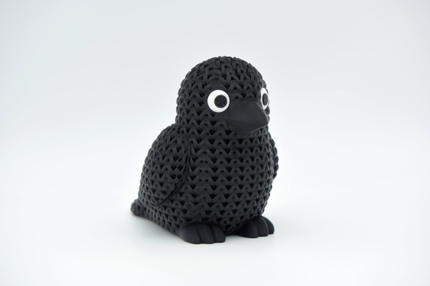 Texture detail of the knitted crow figure showing the yarn-like surface pattern and feather definition