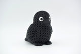 Texture detail of the knitted crow figure showing the yarn-like surface pattern and feather definition