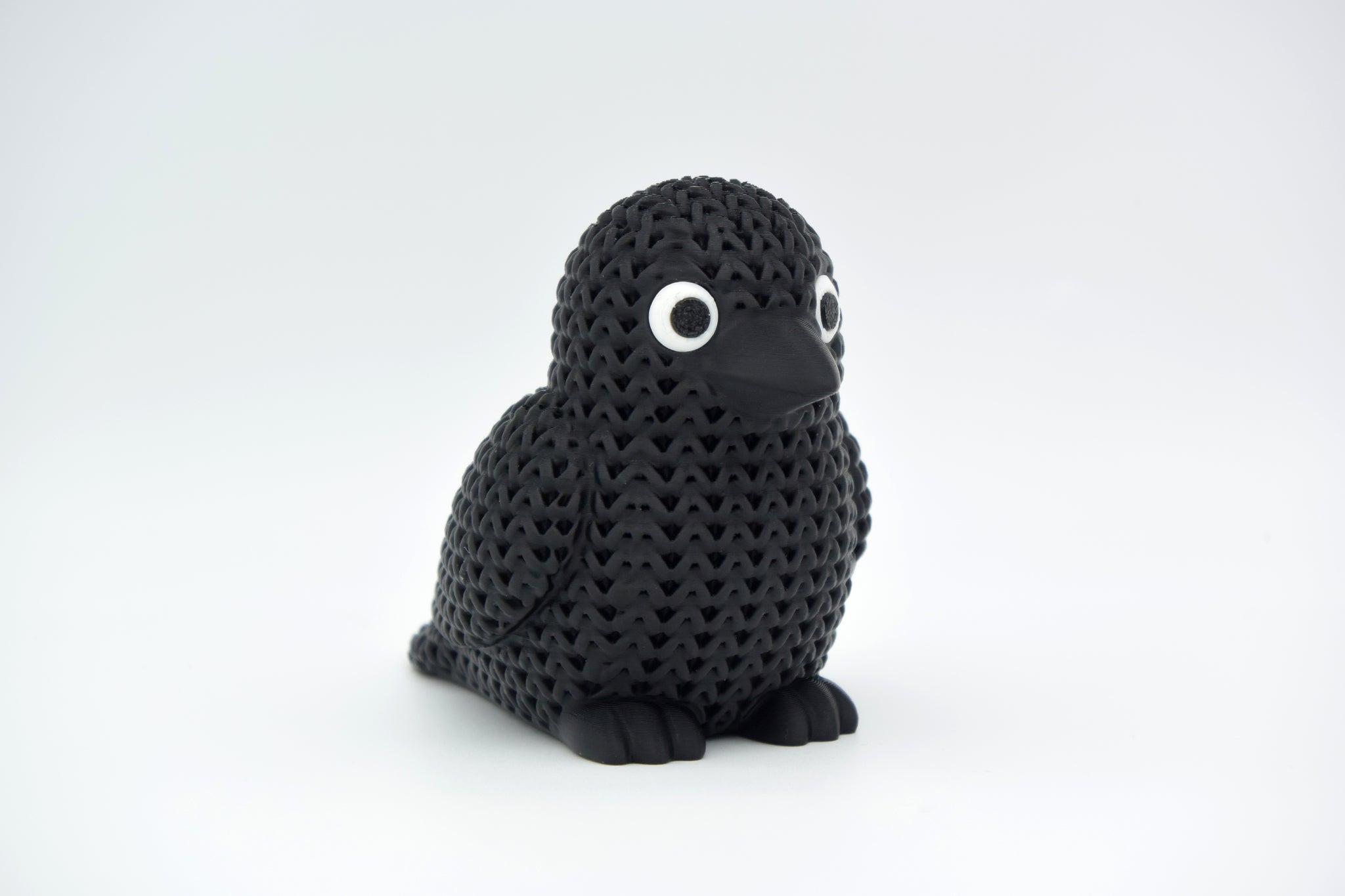Texture detail of the knitted crow figure showing the yarn-like surface pattern and feather definition
