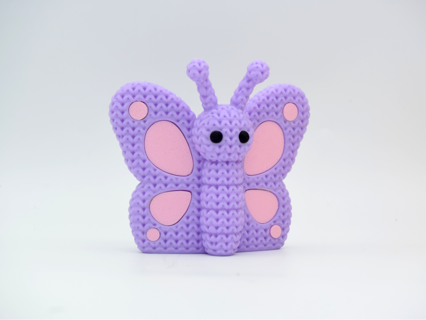 Close-up of a knitted butterfly decoration with crochet-texture wings in warm tones, 49 DKK