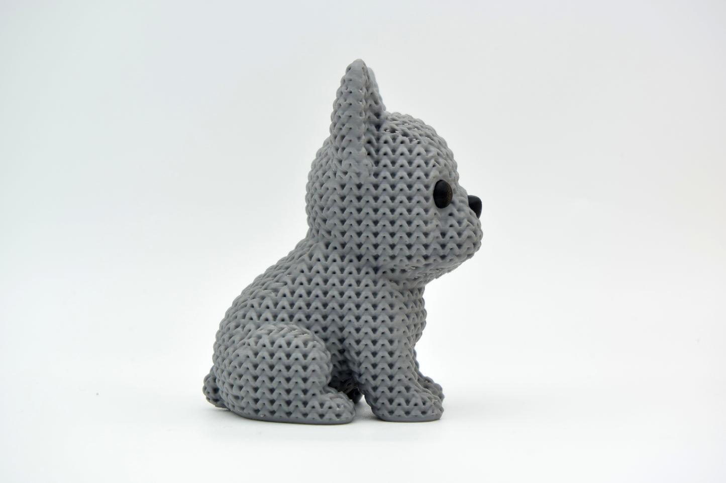 Knitted French Bulldog figure styled on a wooden shelf beside a small plant and neutral home decor accessories