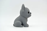 Knitted French Bulldog figure styled on a wooden shelf beside a small plant and neutral home decor accessories