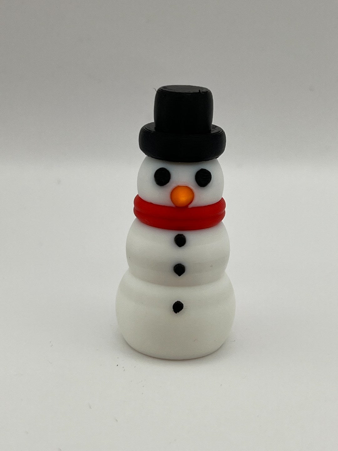 Kleine Schneemannfigur in mehreren Farben